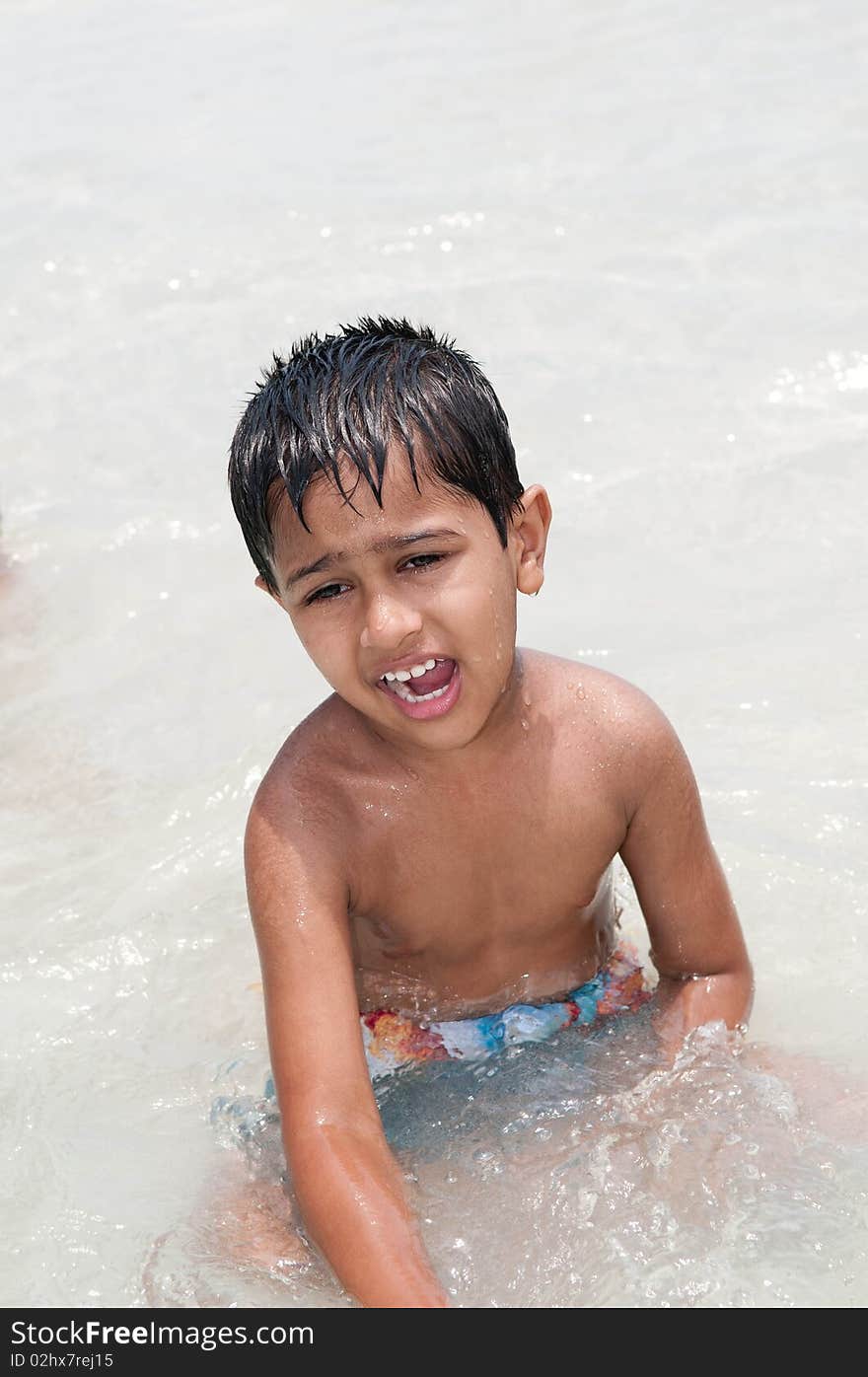 An handsome Indian kid playing in the water