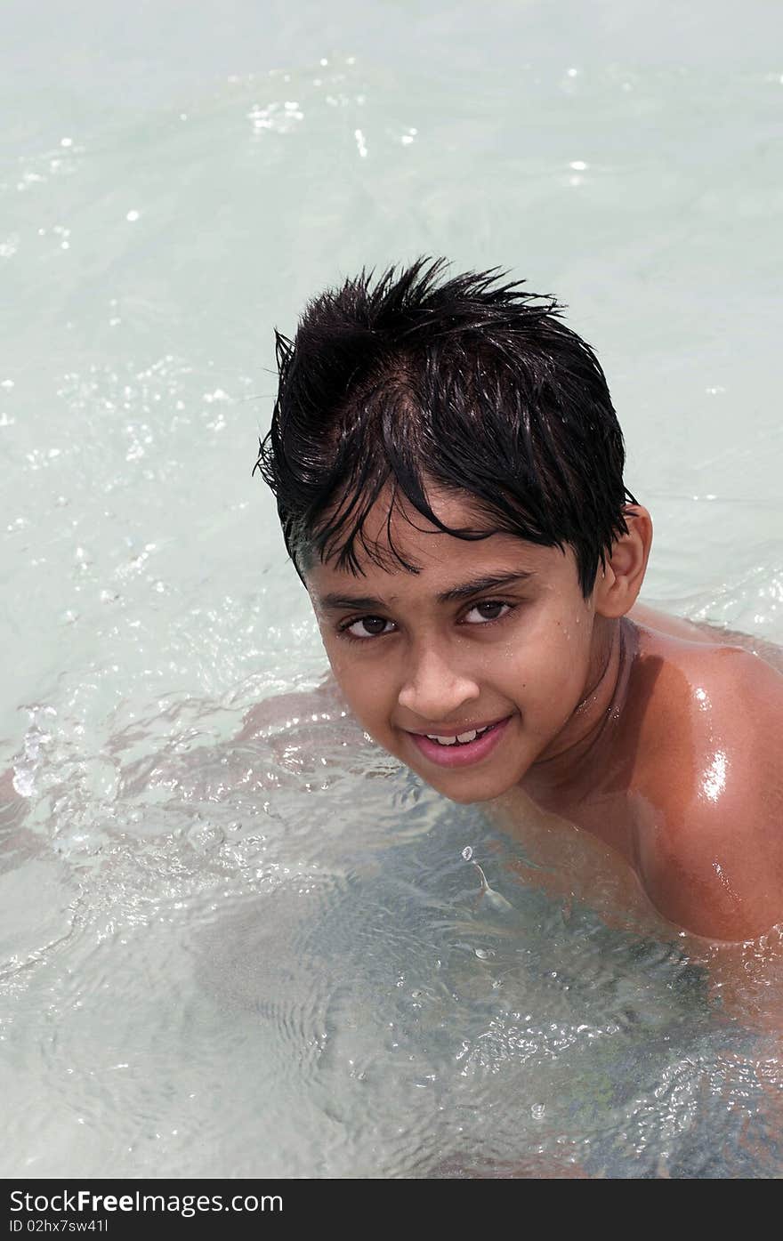 An handsome Indian kid playing in the water