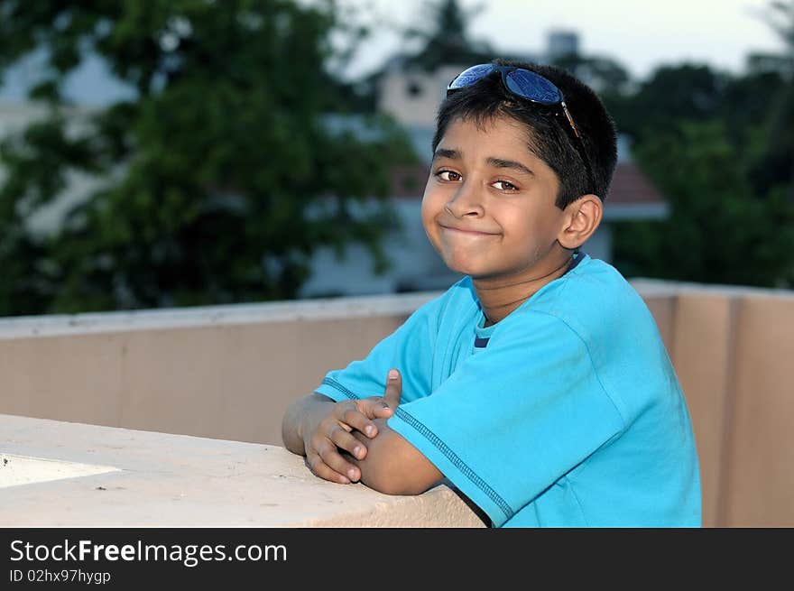 A handsome Indian kid model posing with his sun glasses. A handsome Indian kid model posing with his sun glasses