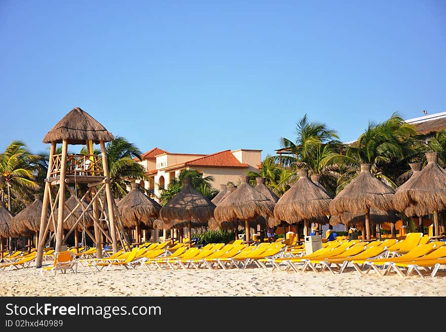 Sand, empty yellow plank beds, grassy umbrellas and the sea. Sand, empty yellow plank beds, grassy umbrellas and the sea.