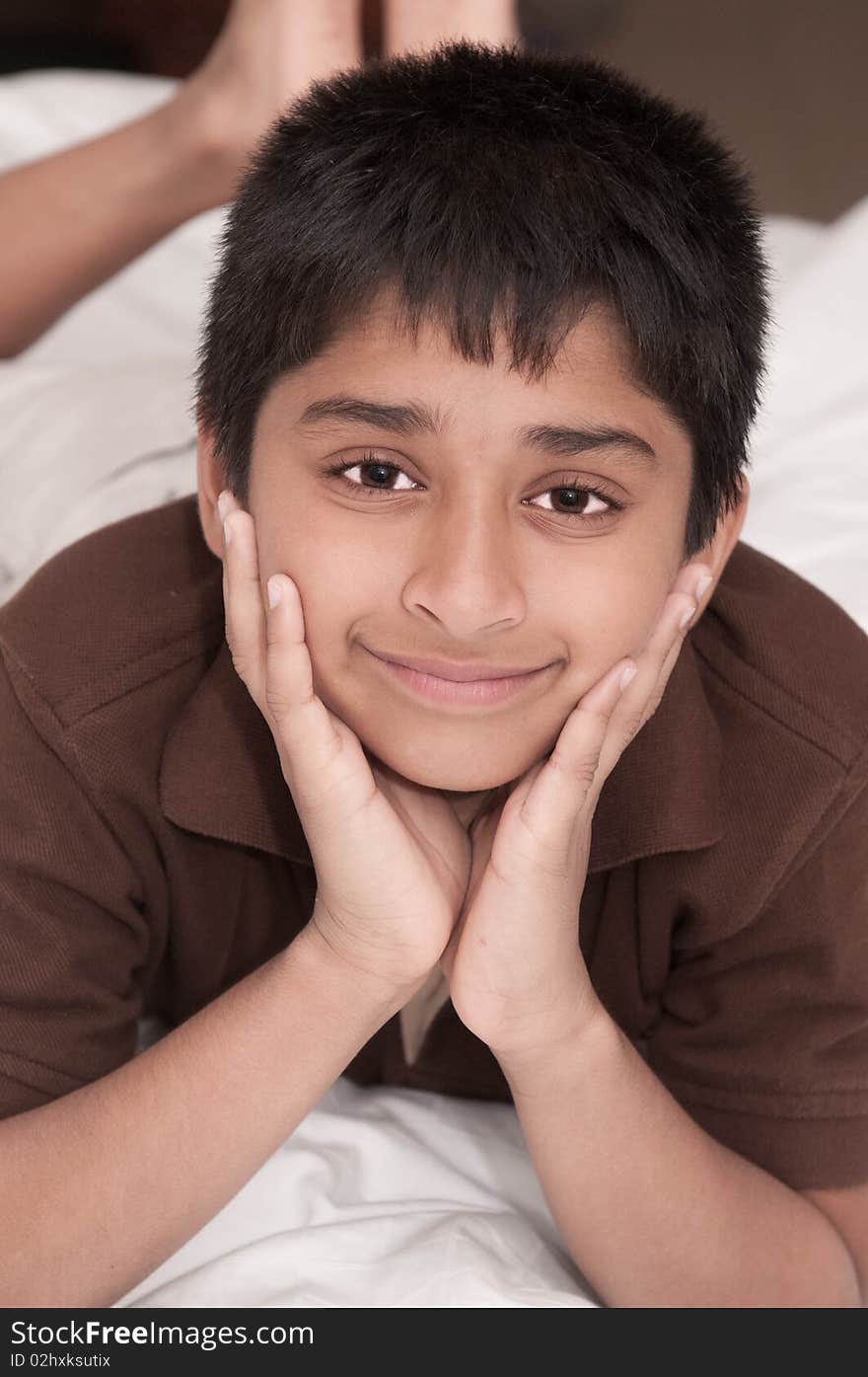 Handsome Indian kid lying happily on the bed. Handsome Indian kid lying happily on the bed