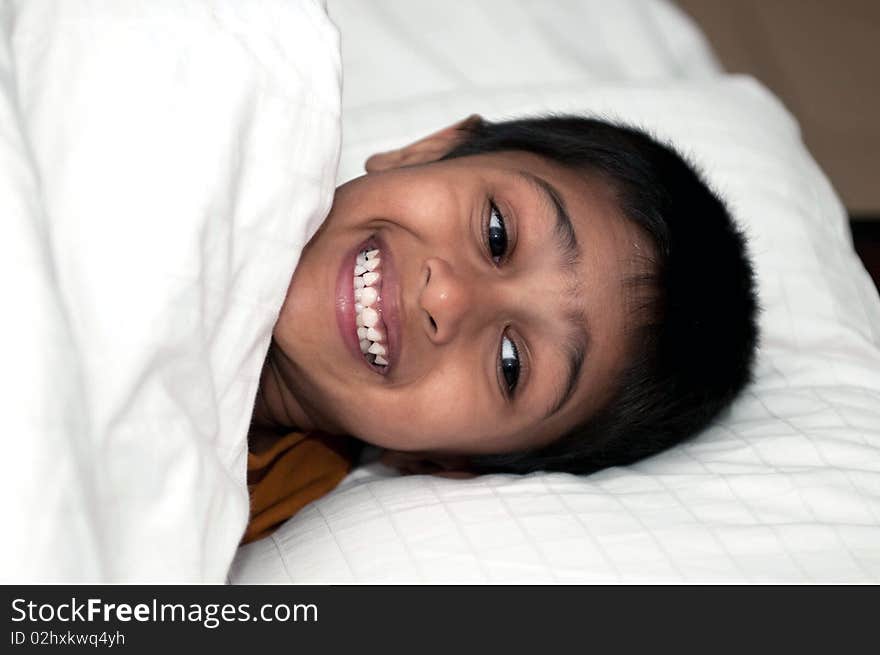 Handsome Indian kid lying happily on the bed. Handsome Indian kid lying happily on the bed