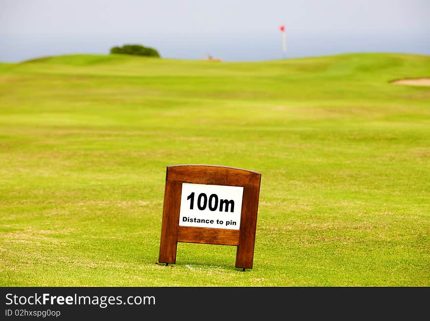 Distance marker on the faiway showing 100m to the pin. Distance marker on the faiway showing 100m to the pin.