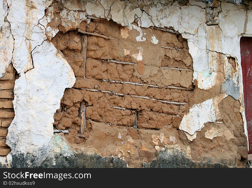 Adobe mud wall with plaster cracking. Adobe mud wall with plaster cracking