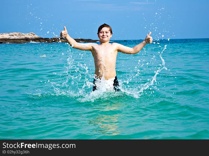 Smiling boy enjoys swimming  in the sea