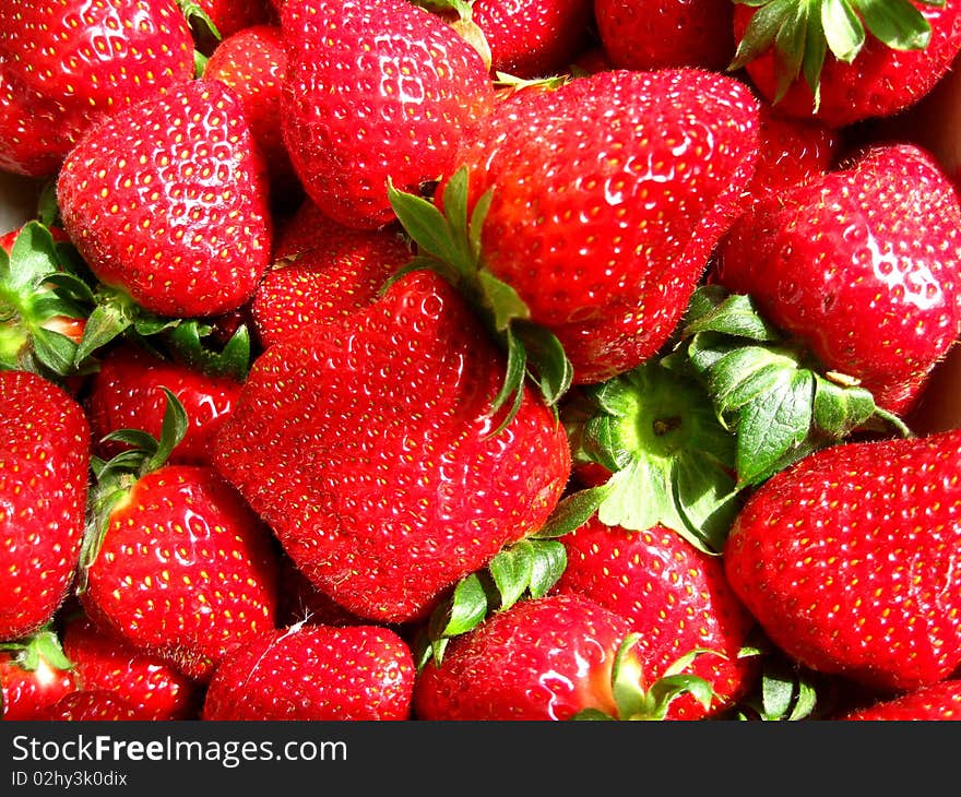 Red strawberries on a pile on a market