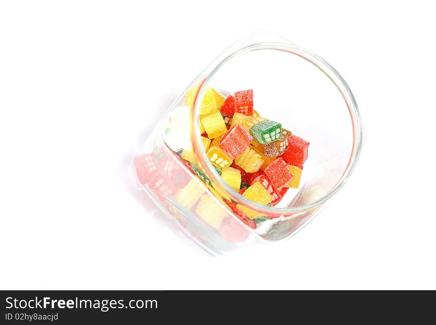 Delicious sweet candies in sugar in a glass jar. white background. copy-space