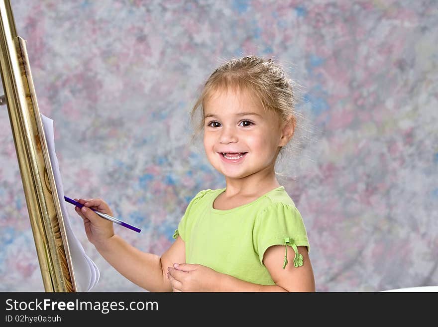 Cute little girl in green blouse painting with water colors. Painted background. Cute little girl in green blouse painting with water colors. Painted background.