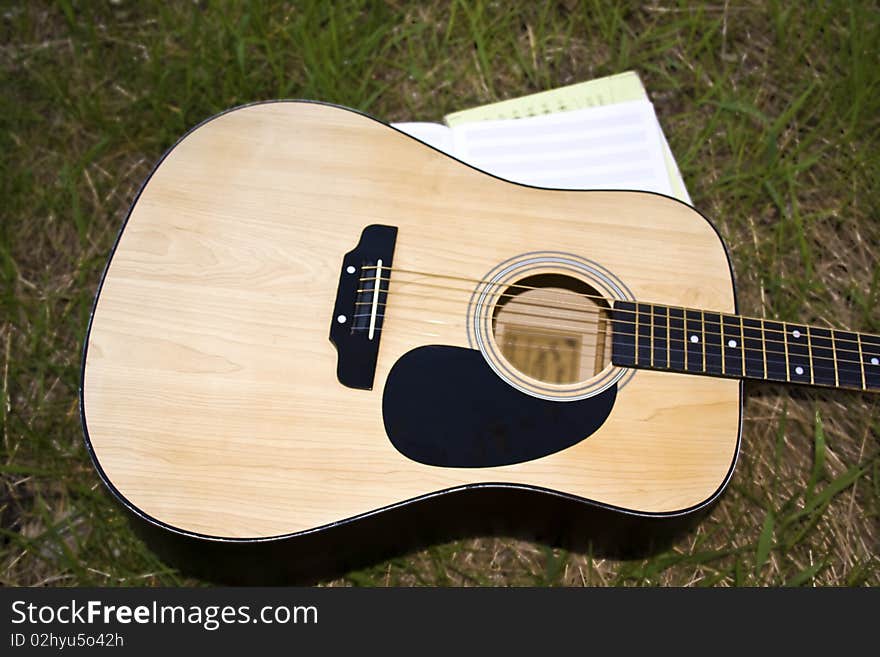 The guitar and a notebook for music on the lawn