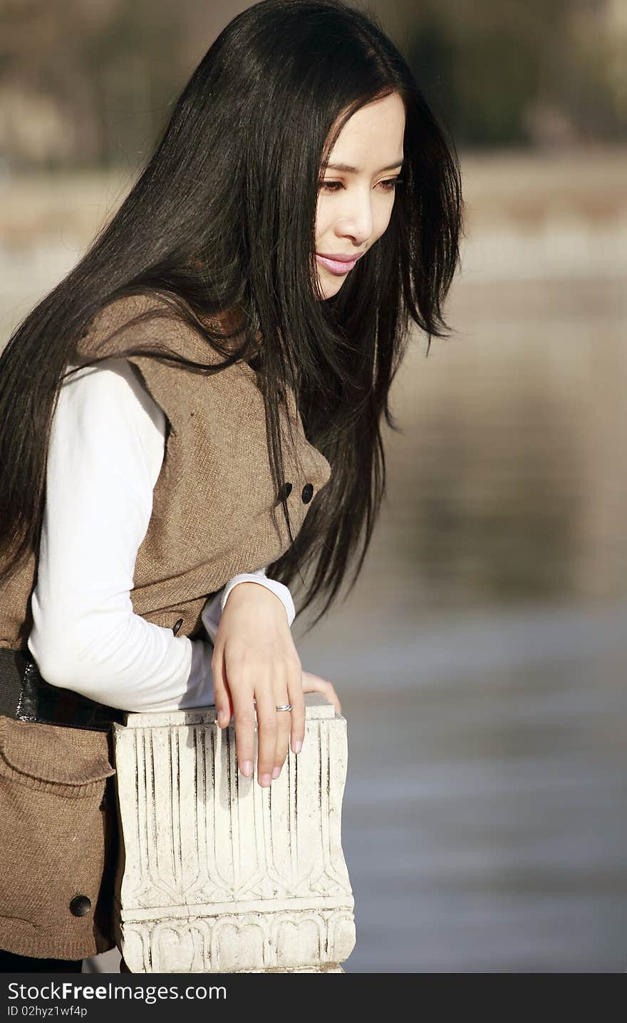 Young Asian woman pondering by the river. Young Asian woman pondering by the river.