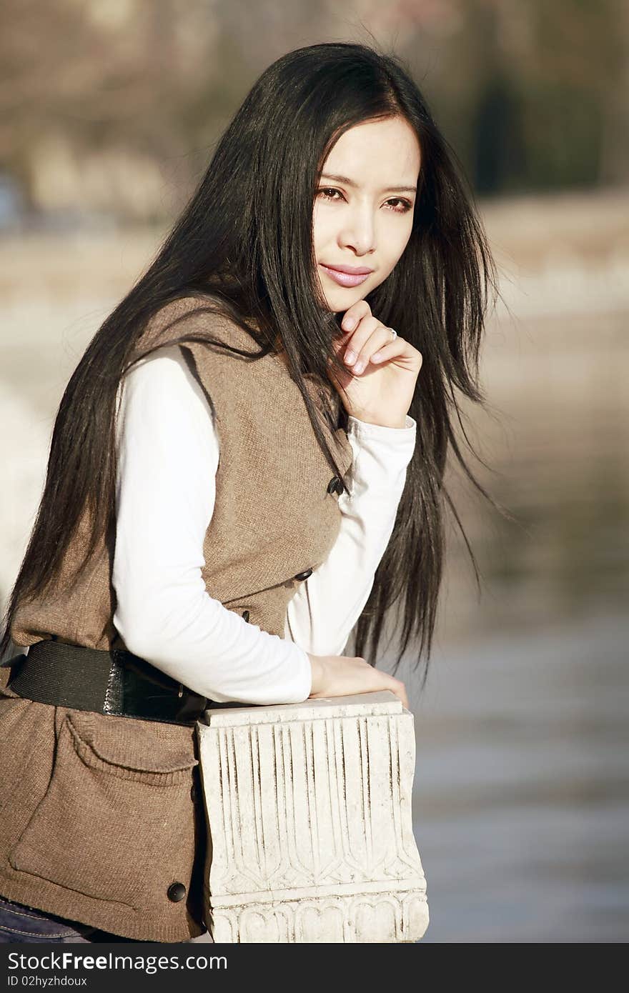 Young Asian girl pondering by the river. Young Asian girl pondering by the river.