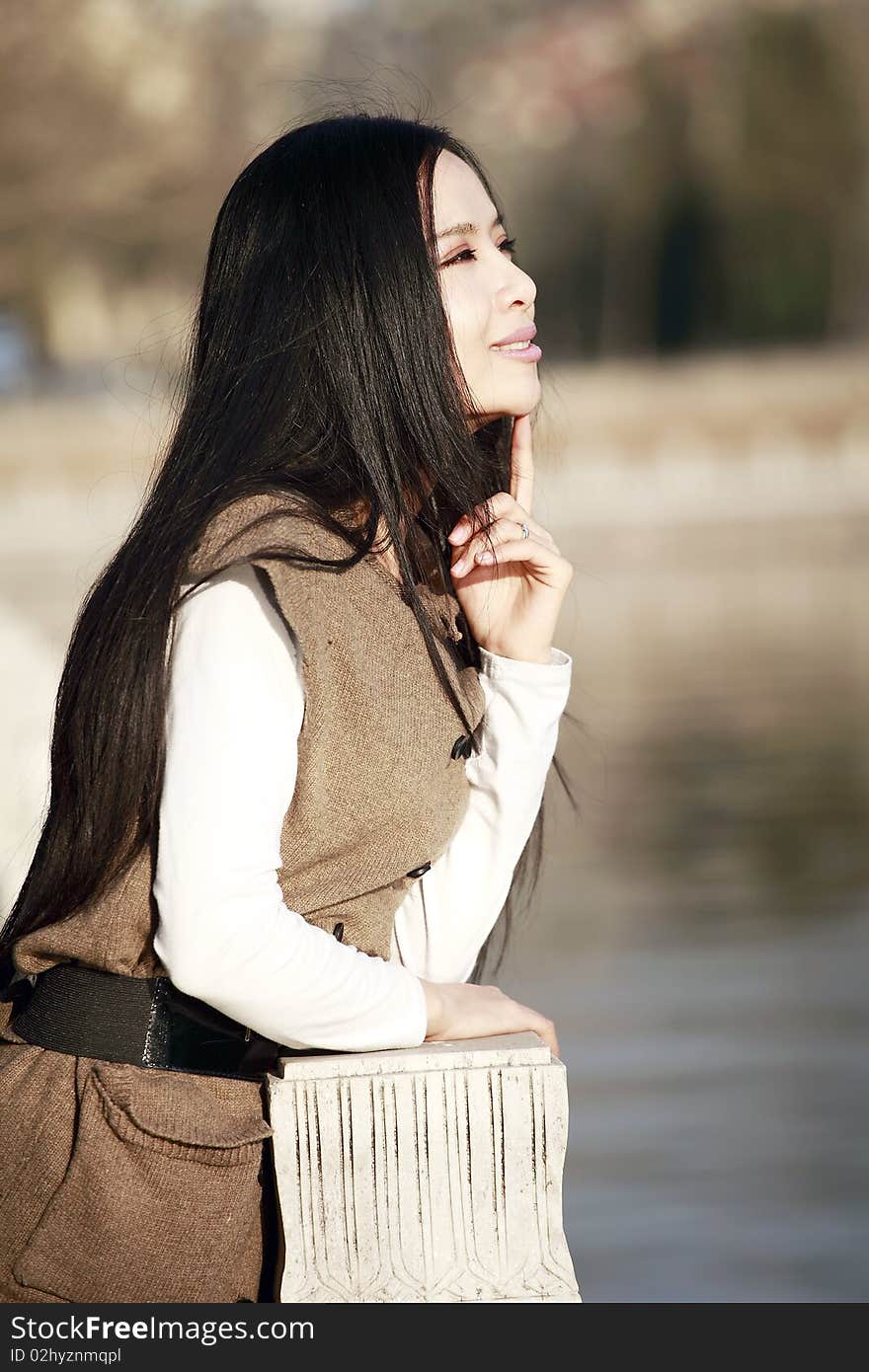 Asian girl enjoying spring scenery by the river. Asian girl enjoying spring scenery by the river.