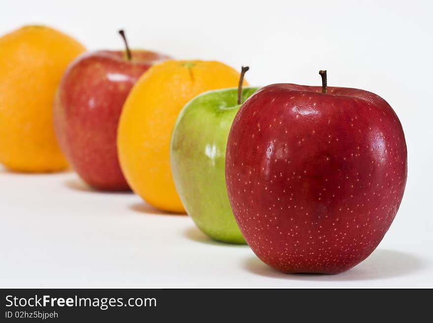 Close-up of a row of apples and oranges.