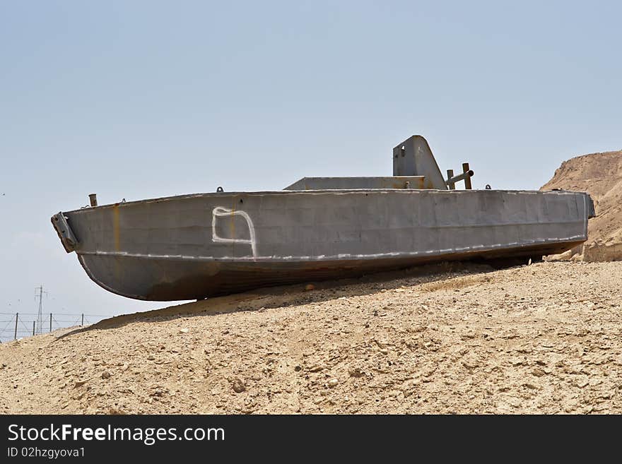 Abandoned shipwreck of steel boat in desert against blue sky. Abandoned shipwreck of steel boat in desert against blue sky