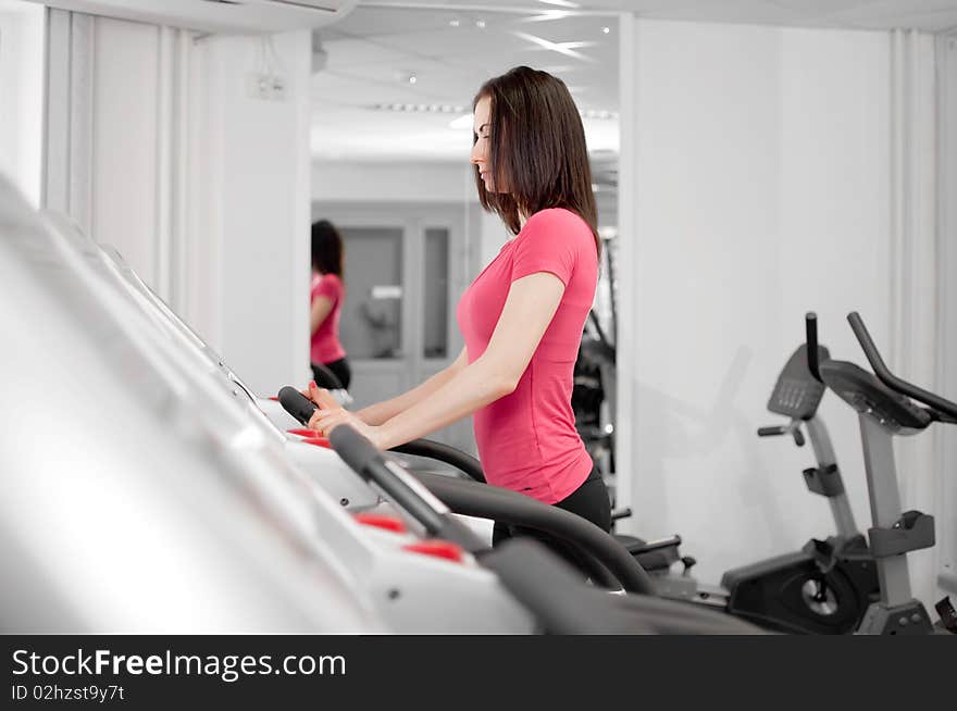 Pretty young woman on a running simulator