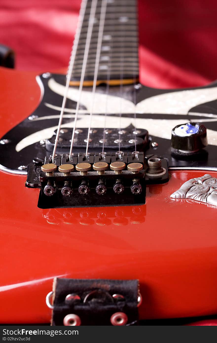 Close-up on an electric guitar on red satin background. Close-up on an electric guitar on red satin background