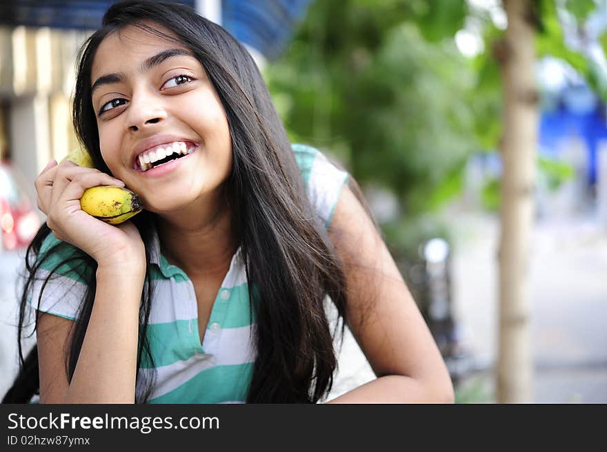 Girl giving talking expression with banana. Girl giving talking expression with banana