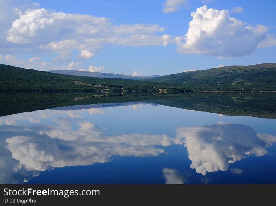 Sky and horizon reflecting in a mountain lake. Sky and horizon reflecting in a mountain lake