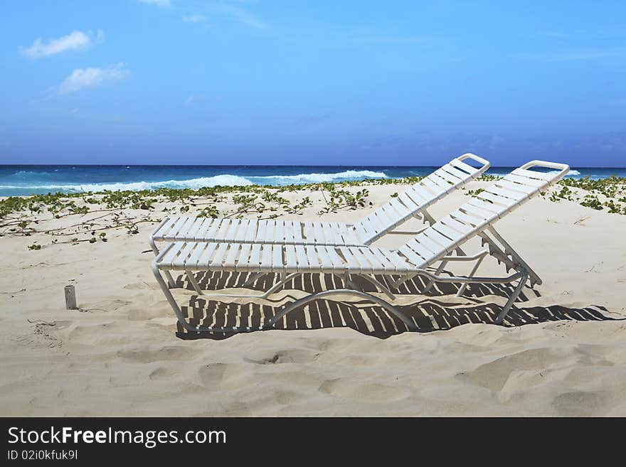 Profile view of a pair of beach lounge chairs on one of Barbados beautiful beaches. Profile view of a pair of beach lounge chairs on one of Barbados beautiful beaches.