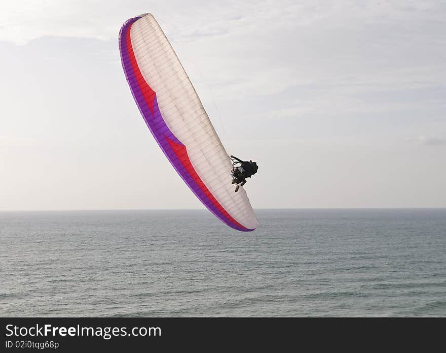 Paraglider diving toward the sea