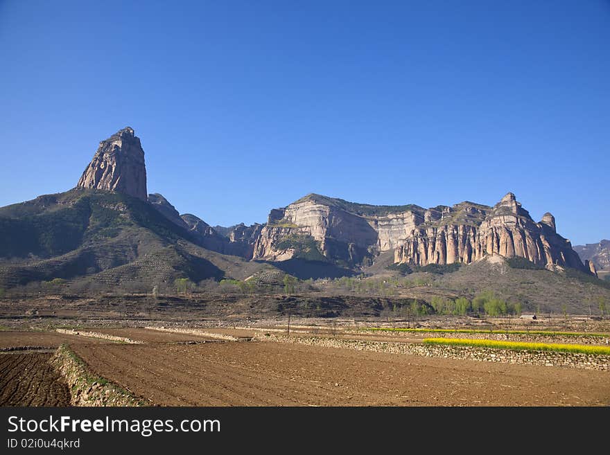 The uncultivated fields at the foot of the rocky mountains in China. The uncultivated fields at the foot of the rocky mountains in China