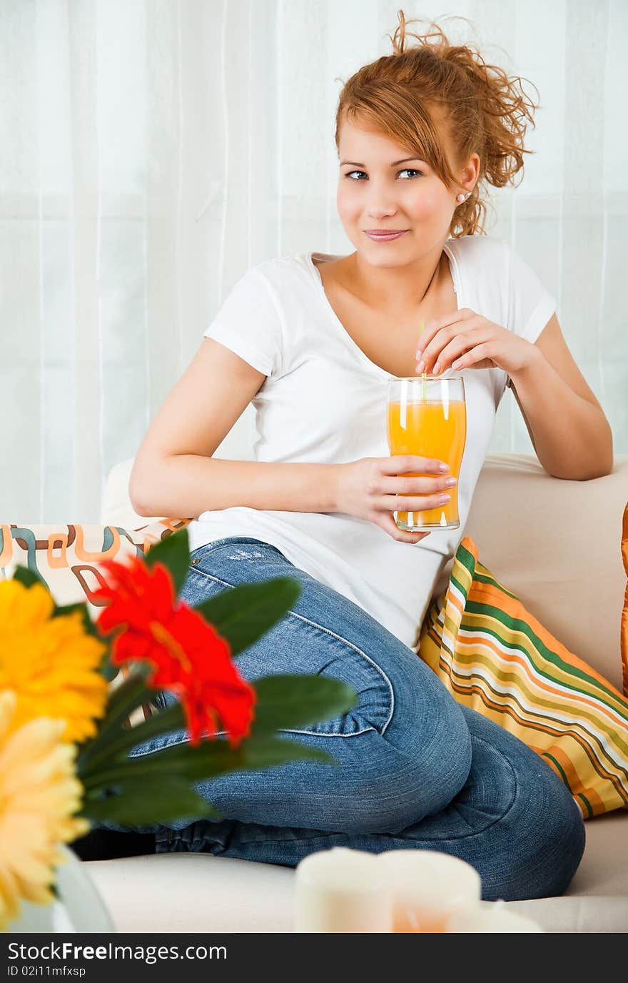 Beauty, young girl with a glass of orange juice at home