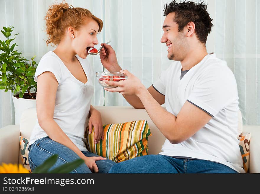 Handsome boy feeding a young, beauty girl strawberry. Handsome boy feeding a young, beauty girl strawberry