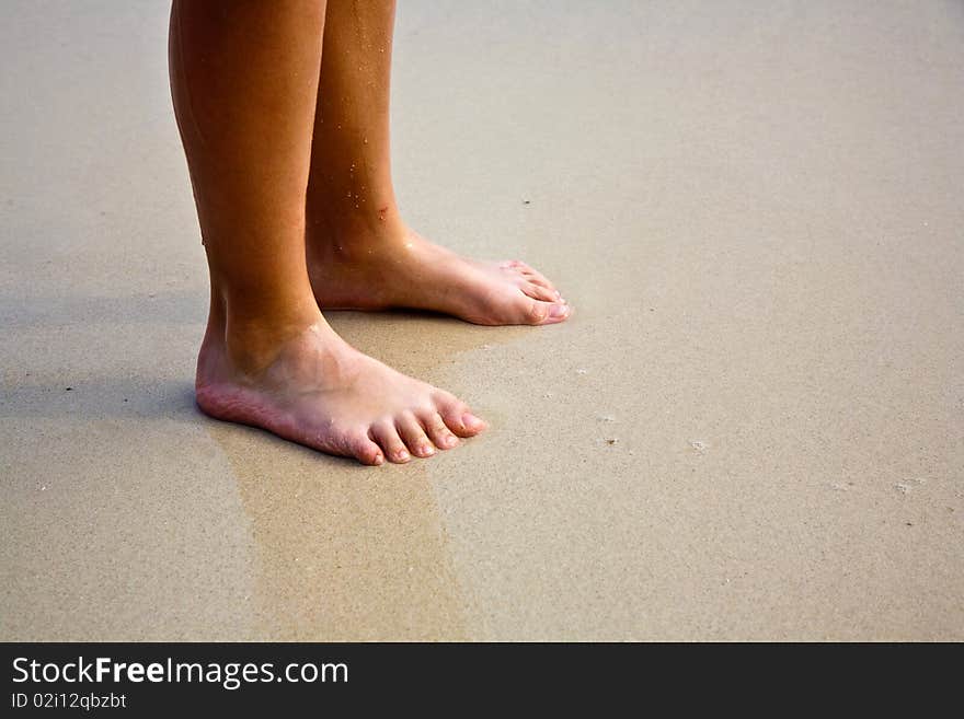 Feet on the beautiful sandy beach. Feet on the beautiful sandy beach