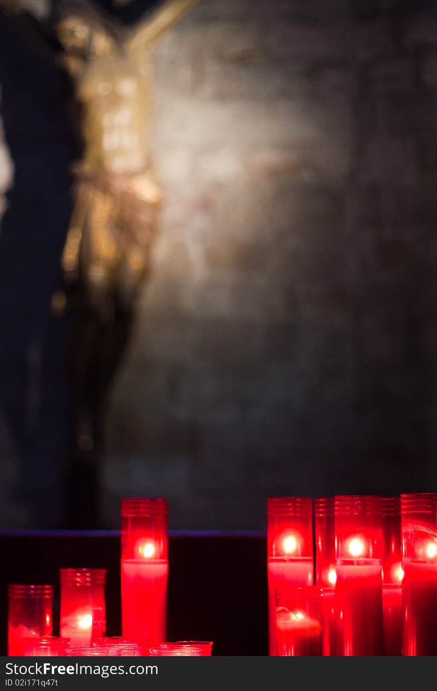 Religious statue with candles in foreground form church interior. Religious statue with candles in foreground form church interior