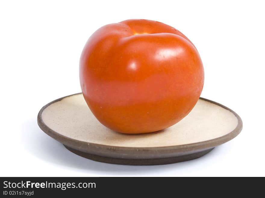 Tomato on a plate isolated on the white background