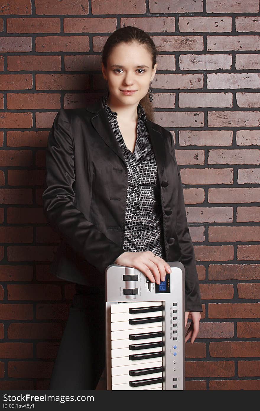 Portrait of musician with midi key board near brick wall