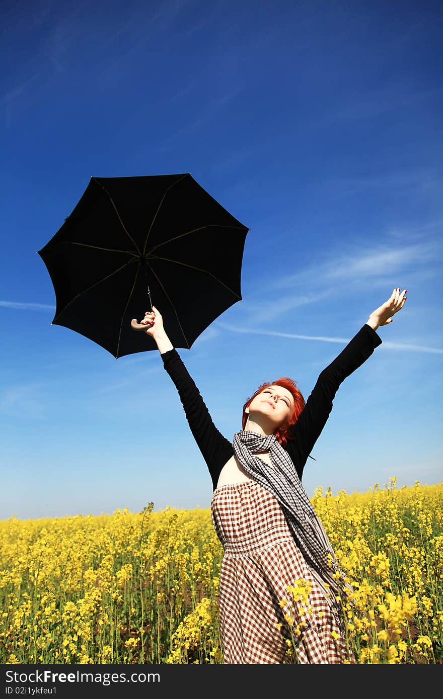 Girl with umbrella at rape field. Photo 3.