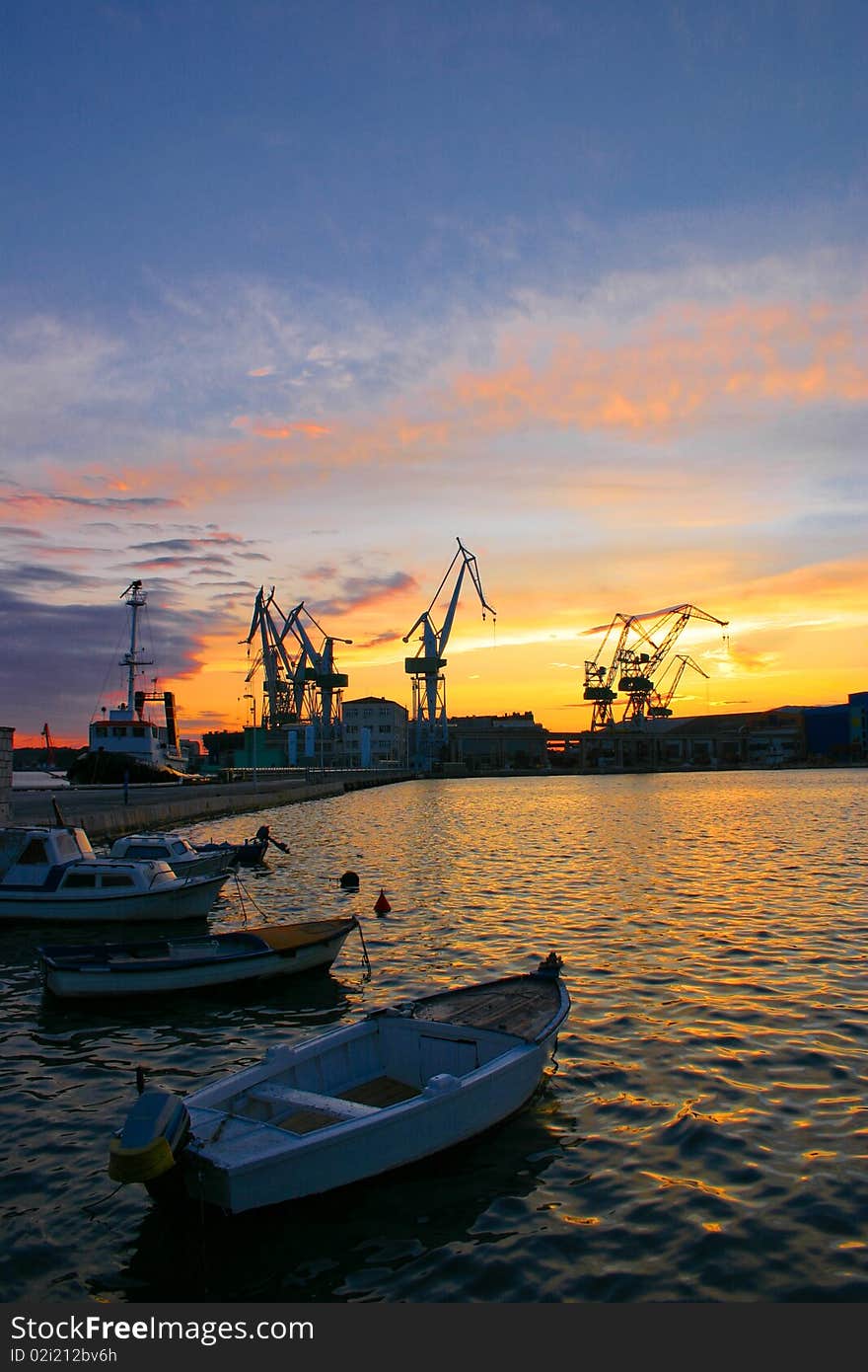 Harbor with cranes and boats at sunset. Harbor with cranes and boats at sunset