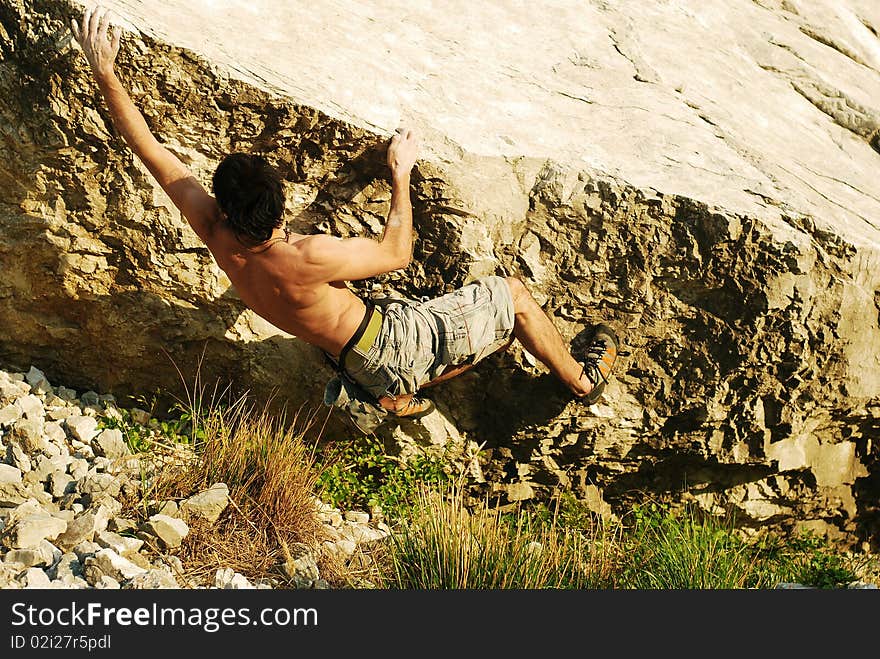 Climber reaching the next hold on a boulder climb. Climber reaching the next hold on a boulder climb