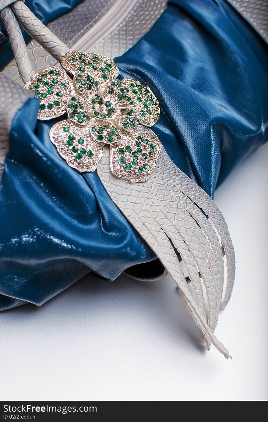 Part of the woman's hand bag decorated with the metal flower