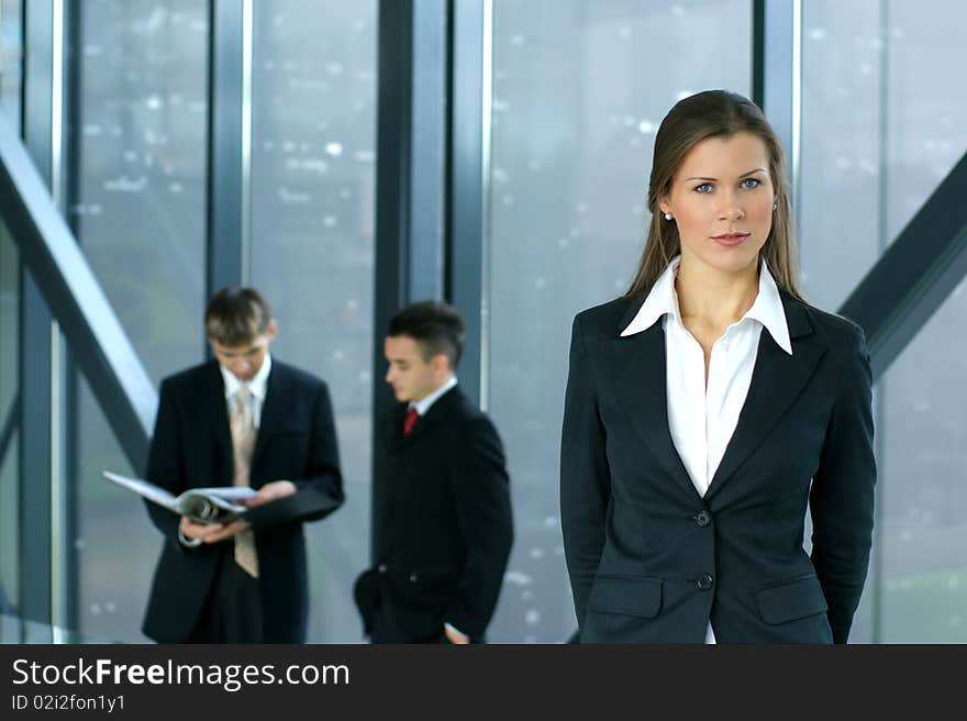 A young business woman in front of her colleagues in a modern office. A young business woman in front of her colleagues in a modern office.