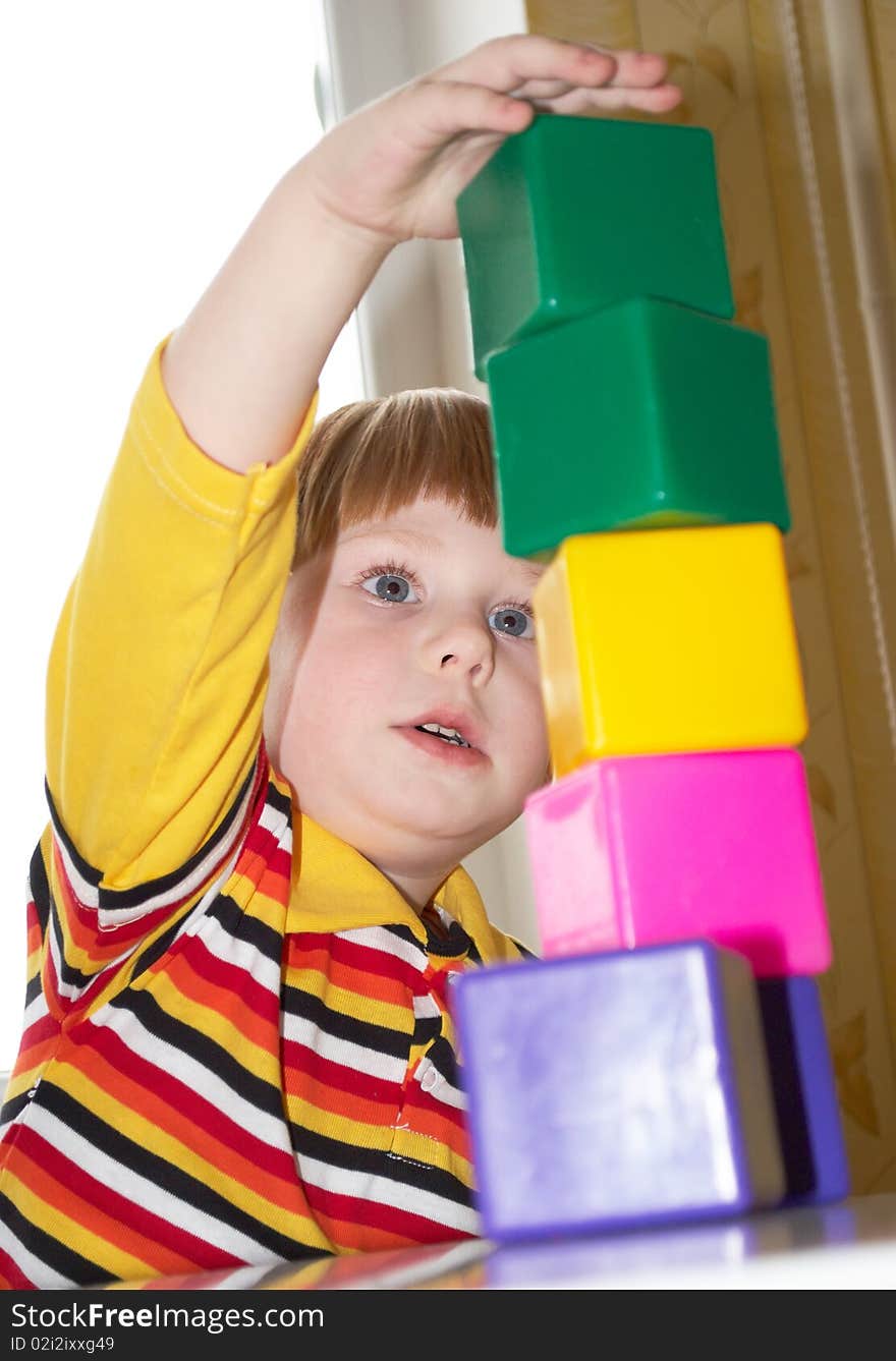 The beautiful little boy poses on a light background. The beautiful little boy poses on a light background