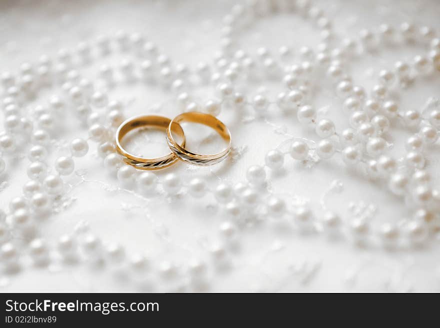 Two wedding rings on white background with beads