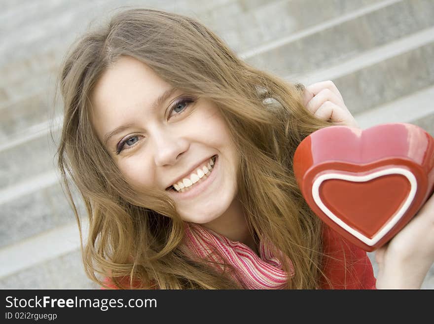 A beautiful young woman holding a red heart. Valentine. A beautiful young woman holding a red heart. Valentine