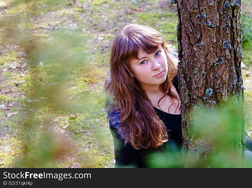 Young woman near the tree in the forest, in a sunny spring day. Young woman near the tree in the forest, in a sunny spring day