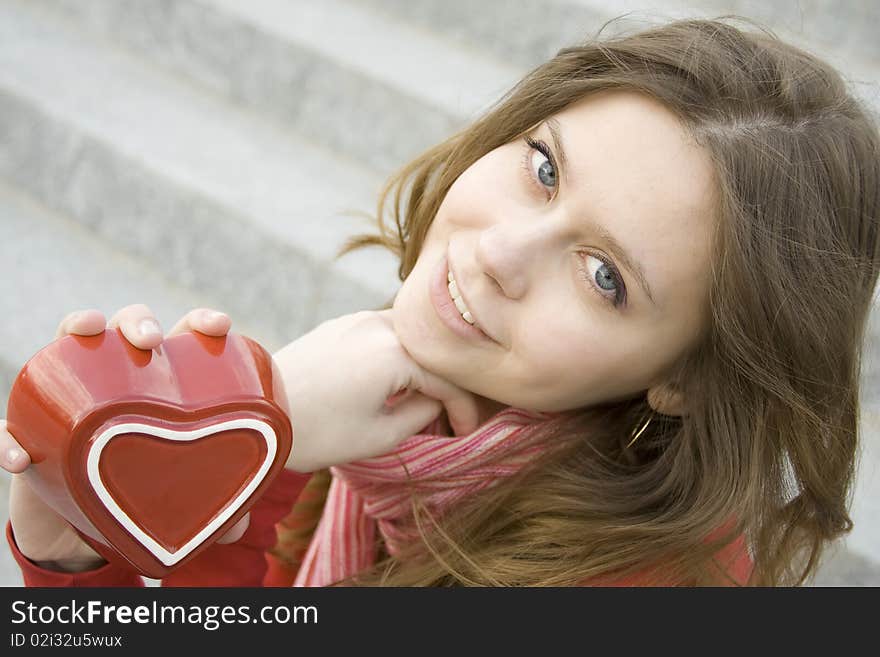 A beautiful young woman holding a red heart. Valentine. A beautiful young woman holding a red heart. Valentine