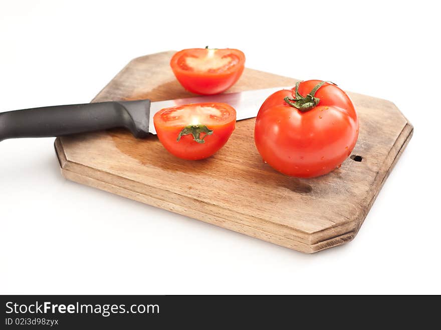 Fresh tomatoes and a knife on a worktop