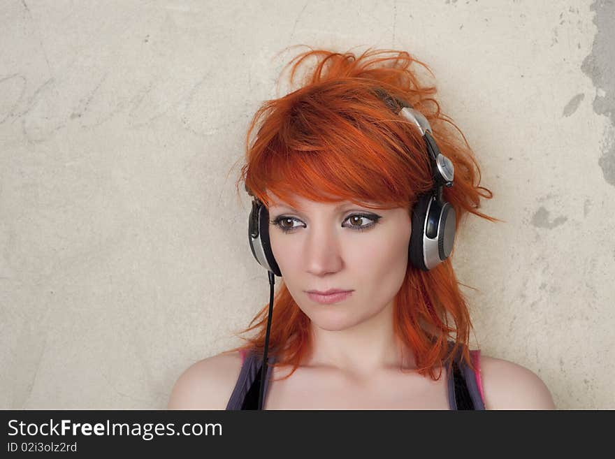 Young woman with headphones posing on a vintage background. Young woman with headphones posing on a vintage background