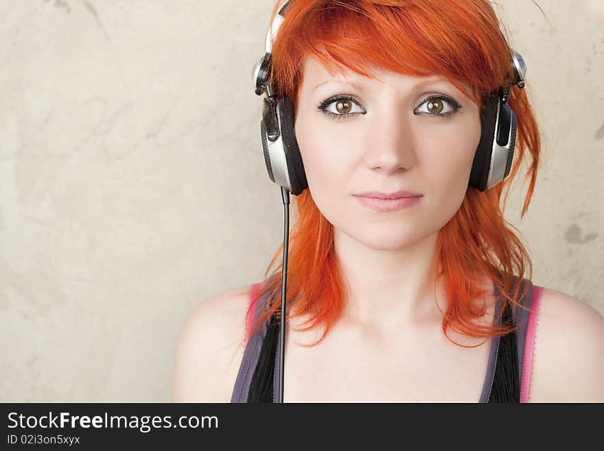 Young woman with headphones posing on a vintage background. Young woman with headphones posing on a vintage background