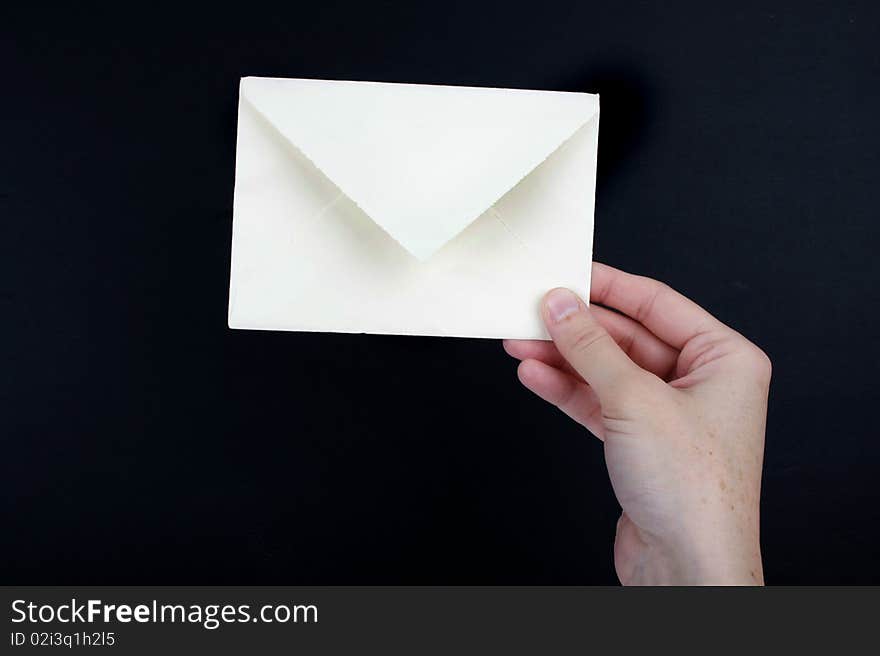 Hand holding a white envelope