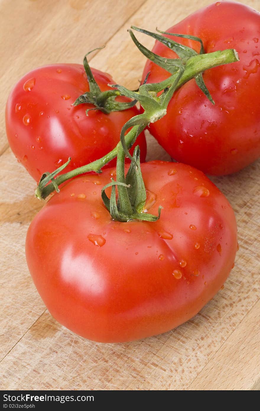 Fresh tomatoes on wooden cutting board