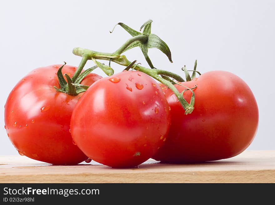 Fresh tomatoes on wooden cutting board