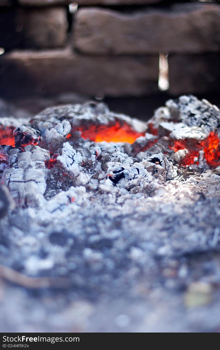 Burning red hot coals on the background of brick wall