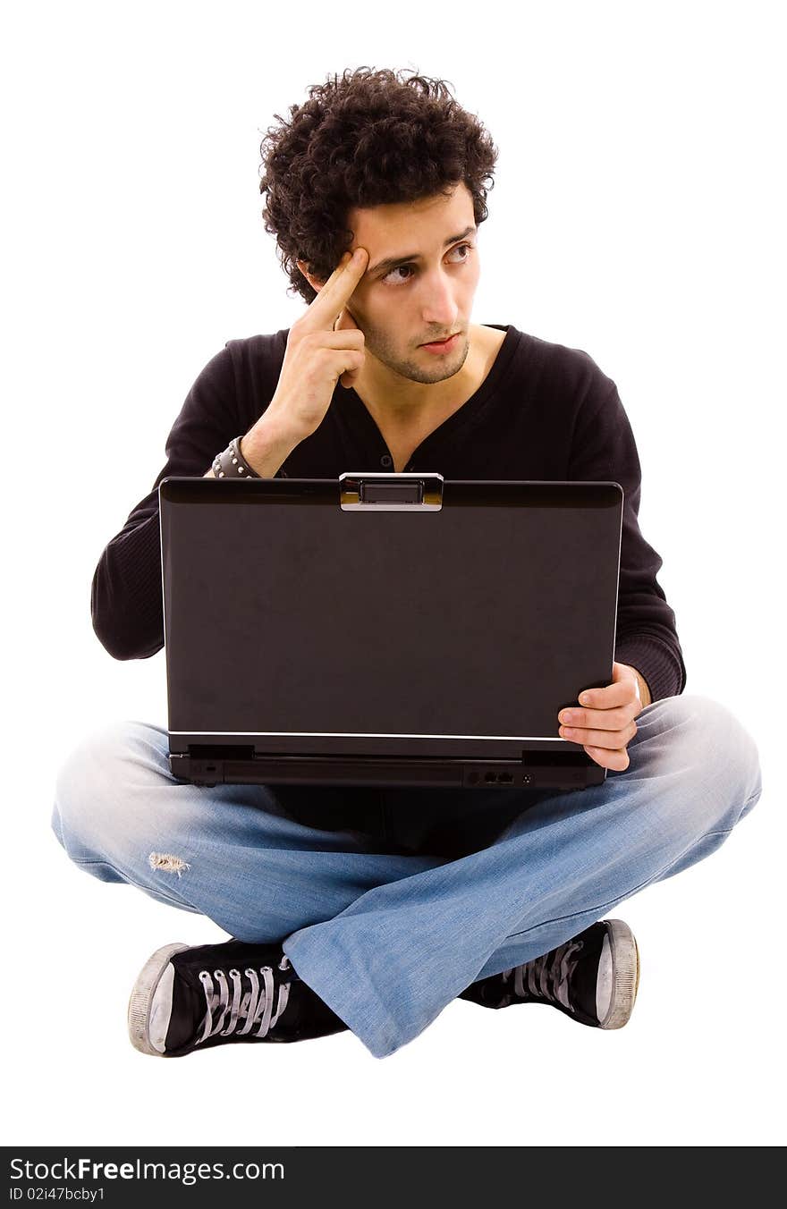 Pensive young man sitting on floor using laptop, isolated on white