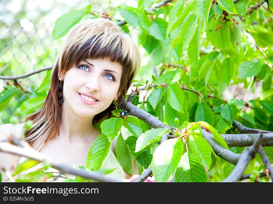 Beautiful young girl enjoying the sunny day in an orchard. Beautiful young girl enjoying the sunny day in an orchard